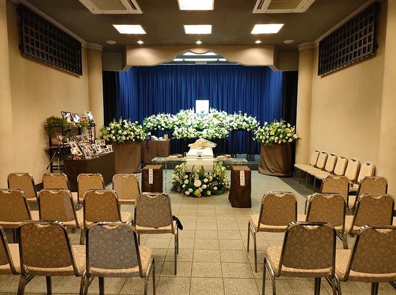 奥には白を基調とした花で作られた祭壇があり、手前には椅子が並べられています。